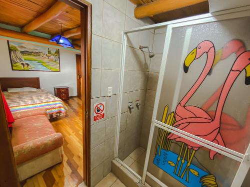 a bathroom with a shower with a pink flamingo painted on the wall at Hostería Chukirawa in Quilotoa