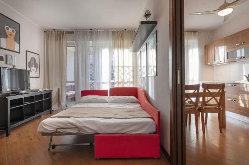 Opi's home with terrace في بوكيناسكو: غرفة نوم بسرير احمر ومطبخ