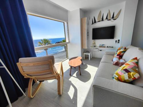 a living room with a couch and a large window at Vacacional Sunbeach Candelaria in Candelaria