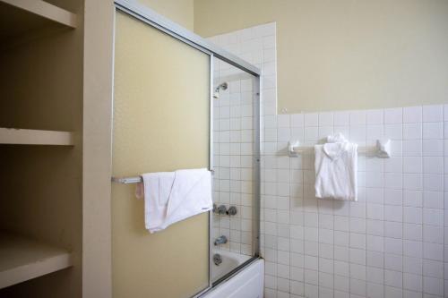 y baño con ducha y toallas blancas. en Ocean Front Triple Room at Sahara Hotel, en Montego Bay
