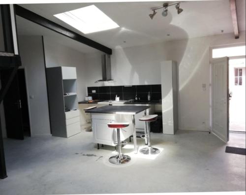 uma cozinha com um balcão e dois bancos em loft a montargis em Montargis