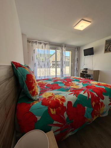 a bedroom with a bed with a colorful comforter at Maison de campagne entre vigne et bois in Chablis