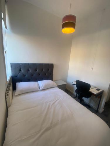 ein Schlafzimmer mit einem Bett, einem Schreibtisch und einer Lampe in der Unterkunft Cozy One Room- Ideal for Getaways in Bury