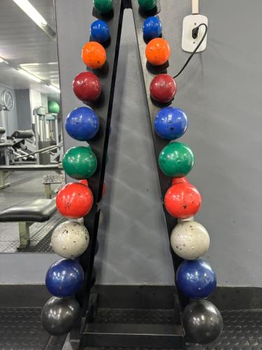 a row of bowling balls in a gym at Apt perto da praia com vaga e serv de arrumadeira in Rio de Janeiro