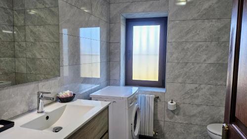 a bathroom with a sink and a toilet and a window at Casa de Aldea la Piniella in Villahormes