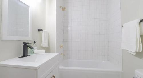 a white bathroom with a sink and a shower at Modern Chateau Remodeled Home Close to Downtown in Mobile