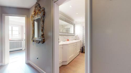 ein Badezimmer mit einem Spiegel und einem Waschbecken in der Unterkunft Strönholt in Archsum