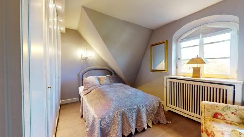 ein kleines Schlafzimmer mit einem Bett und einem Fenster in der Unterkunft Strönholt in Archsum