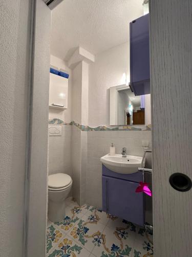 a bathroom with a toilet and a sink at LA BOMBONIERA in Ischia