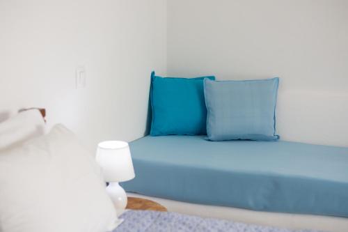 a blue bed with blue pillows in a room at Sarantis Suites & Apartments in Provatas