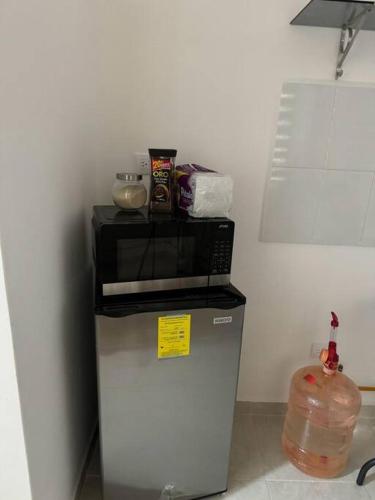 a microwave on top of a refrigerator in a kitchen at Dep completo a 5min del foro sol, y del aeropuerto in Mexico City