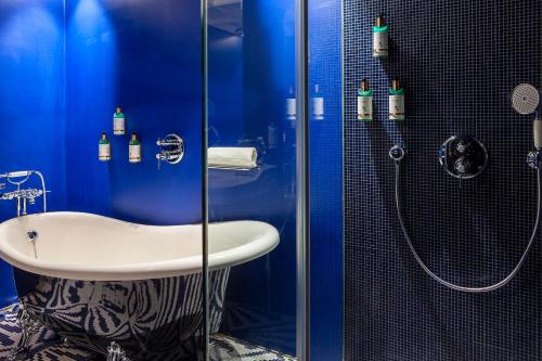 a blue bathroom with a sink and a shower at Art Legacy Hotel Baixa-Chiado in Lisbon