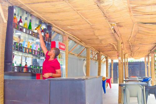 a woman standing at a bar with her arm in the air at Lisgewann Global Hotel in Ijesa-Tedo