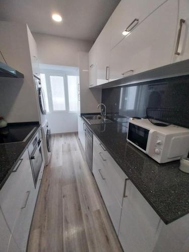 a kitchen with a counter top with a microwave at Bleu Océan in Praia de Mira