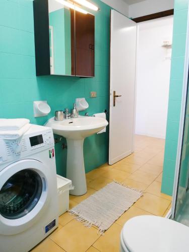a bathroom with a washing machine and a sink at LA RIVA appartamento in Perledo