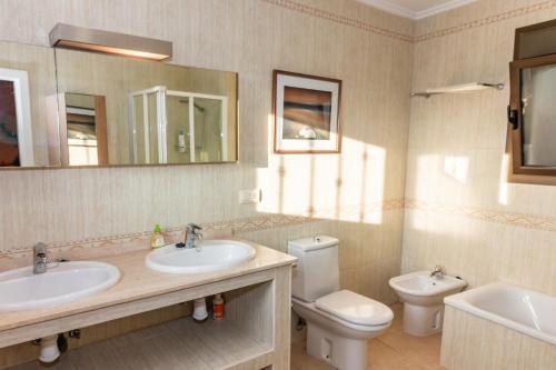 Ador的住宿－Marvelous Ador Dream Villa with Wifi, 3 Bedrooms And Swimming Pool，浴室设有2个水槽、卫生间和镜子。