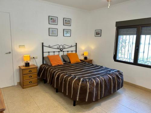 ein Schlafzimmer mit einem Bett mit orangefarbenen Kissen darauf in der Unterkunft Marvelous Ador Dream Villa with Wifi, 3 Bedrooms And Swimming Pool in Ador