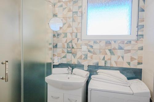a bathroom with a sink and a toilet and a window at Bo's place in St. St. Constantine and Helena