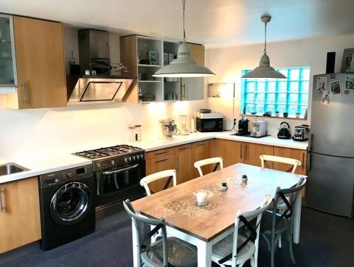 La cuisine est équipée d'une table, d'une cuisinière et d'un réfrigérateur. dans l'établissement La Clarté-House, à Perros-Guirec