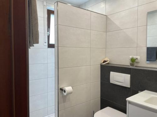 a white bathroom with a toilet and a sink at Apartment Gerberbachviertel in Weinheim