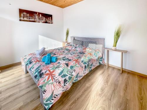 1 dormitorio con 1 cama con colcha colorida en L'Eden Carolo - Netflix, Wi-Fi, 10min Aéroport, Parking gratuit, en Dampremy