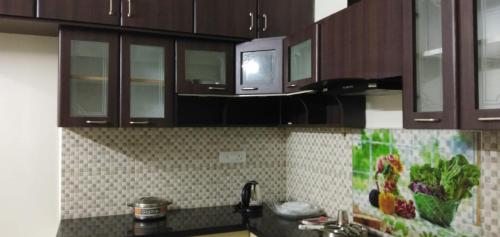 a kitchen with wooden cabinets and a counter top at Bed and Brew in Chennai