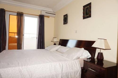 a bedroom with a white bed and a window at Appartement F3 Almadies vue/mer accès+ Dakar in Dakar