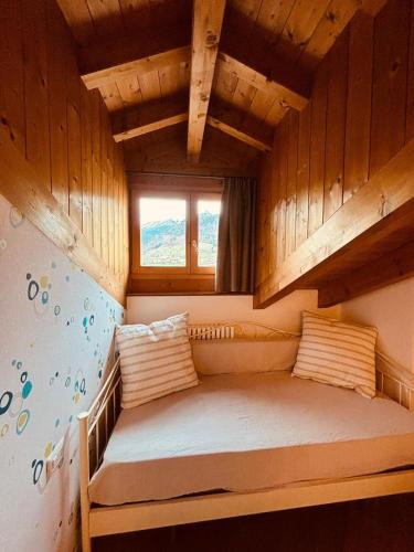 a small bed in a room with a window at Casa Celeste Ledro in Ledro