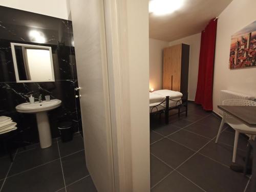 een badkamer met een wastafel en een badkamer met een bed bij Guesthouse The Living Room in Grassobbio