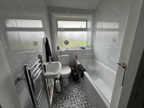 a bathroom with a sink and a toilet and a tub at Holborn in Coundon