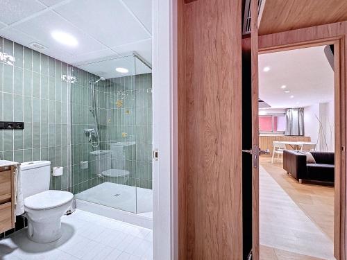 a bathroom with a toilet and a glass shower at El Campello Beach Apartments in El Campello