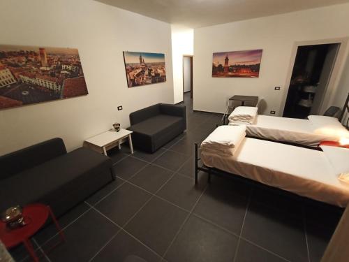 une chambre d'hôtel avec deux lits et un canapé dans l'établissement Guesthouse The Living Room, à Grassobbio
