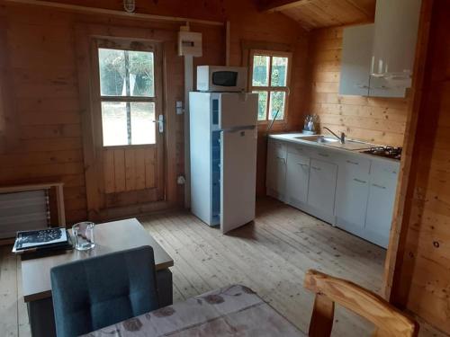 - une cuisine équipée d'un réfrigérateur et d'une table dans une cabine dans l'établissement Val Marie Equitation, à Villeneuve-de-la-Raho