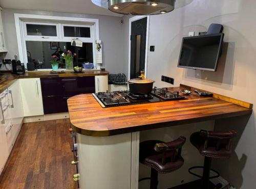 a kitchen with a counter with a stove and a tv at Royal Troon Open Championship 24 in Prestwick