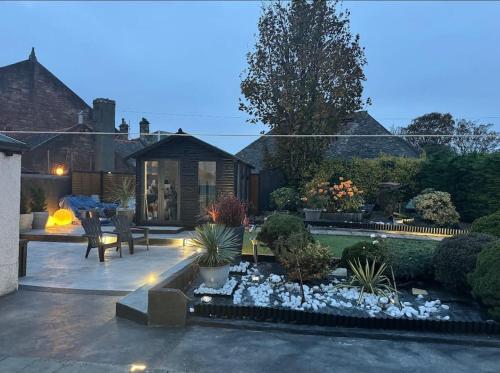 un patio trasero con un jardín con plantas y una casa en Royal Troon Open Championship 24 en Prestwick