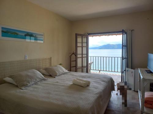 Schlafzimmer mit einem Bett und Meerblick in der Unterkunft Suites Ponta Leste in Angra dos Reis