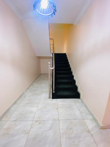 a staircase in a room with a tile floor and a chandelier at Eden Haven in Lagos