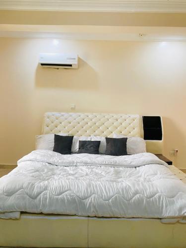 a bedroom with a large white bed with black pillows at Eden Haven in Lagos