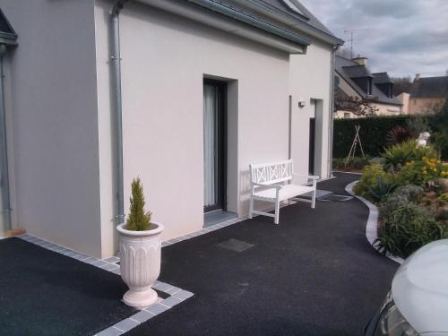 a white bench sitting on a porch of a house at 6bis rue de la boussaquiere st broladre in Saint-Broladre