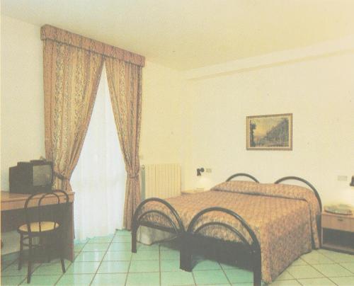 - une chambre avec un lit, une télévision et une fenêtre dans l'établissement HOTEL SAN FRANCESCO INN, à Stroncone