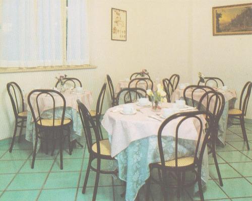 un groupe de tables et de chaises dans une pièce dans l'établissement HOTEL SAN FRANCESCO INN, à Stroncone