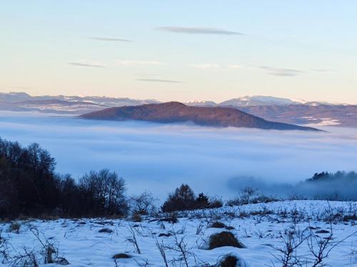 a view of a fog covered field with mountains at Apartmán Bobo in Stožok