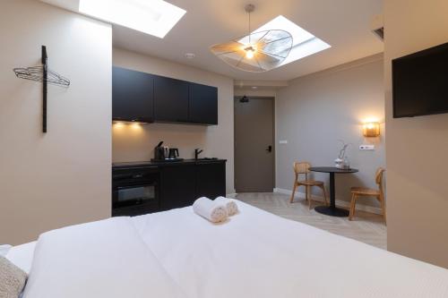 a bedroom with a white bed and a kitchen at SAYŌ Boutique Hotel in Scheveningen