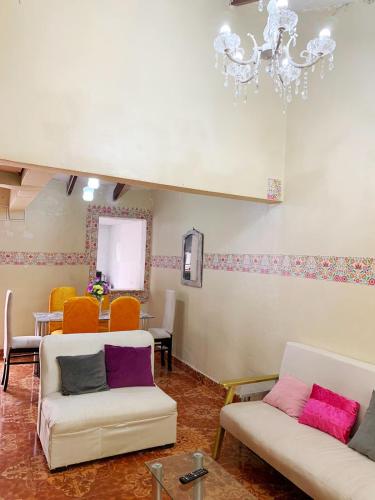 ein Wohnzimmer mit 2 Sofas und einem Kronleuchter in der Unterkunft Alojamiento a 6 cuadras de la plaza in Cusco