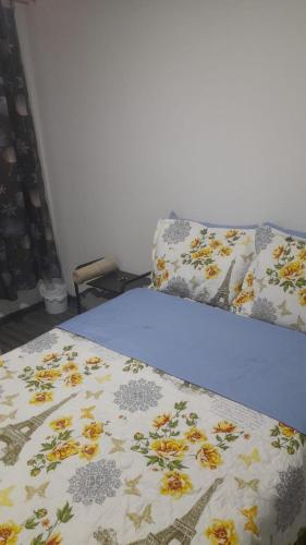 a bed with a blanket with flowers on it at el descanso 2 in Bogotá