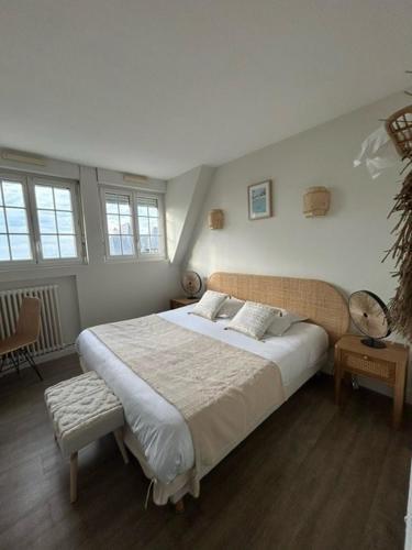 une chambre avec un grand lit et deux fenêtres dans l'établissement Hôtel De La Mer - Deauville Blonville - Boutique Hôtel de charme vue Mer ou Campagne - Accès direct plage, à Blonville-sur-Mer