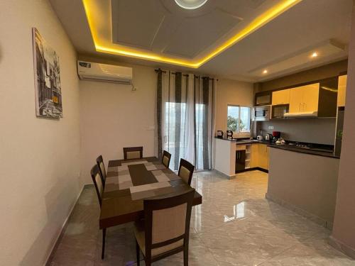 a kitchen and dining room with a table and chairs at Paradis des anges in Yaoundé