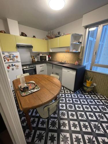 une cuisine avec une table en bois et un réfrigérateur dans l'établissement Appartement dans l'hyper centre, à Avignon