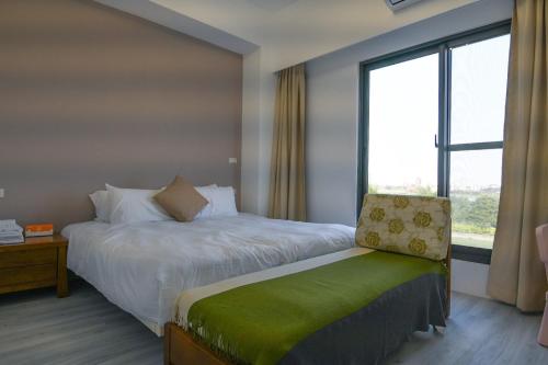 a hotel room with a bed and a window at Love米渡假會館 in Wujie