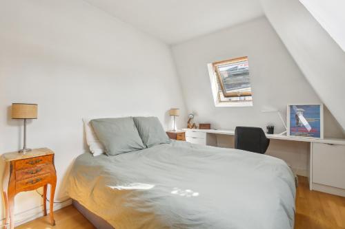 une chambre blanche avec un lit et un bureau dans l'établissement Trocadéro/Victor Hugo - Confort absolu, à Paris